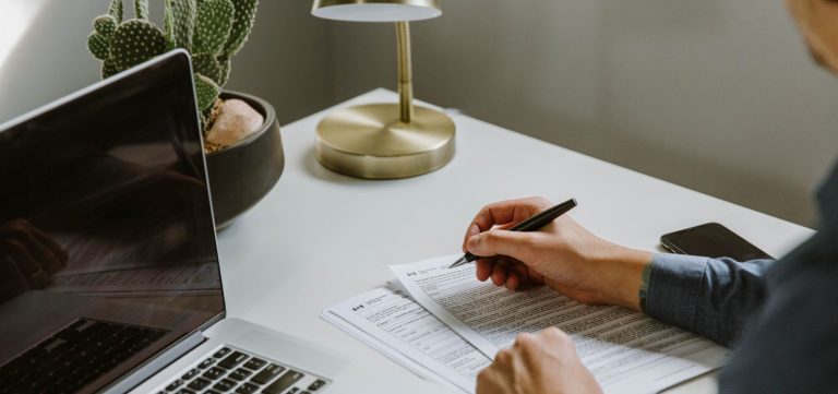 1283398749, iStock-1283398749 von shanf, Lizenz erworben am 28.01.2026 Männliche Person, die ein Steuerformular ausfüllt